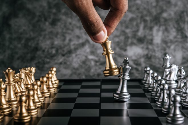 Hand of man playing chess for business planning and comparison of metaphor, selective focus