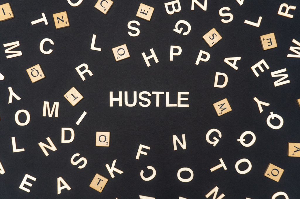 HUSTLE word written on dark paper background. HUSTLE text for your concepts