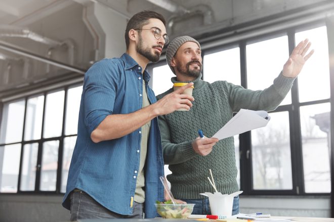 Mature bearded marketing director and his assistant choose place where conduct meeting with business