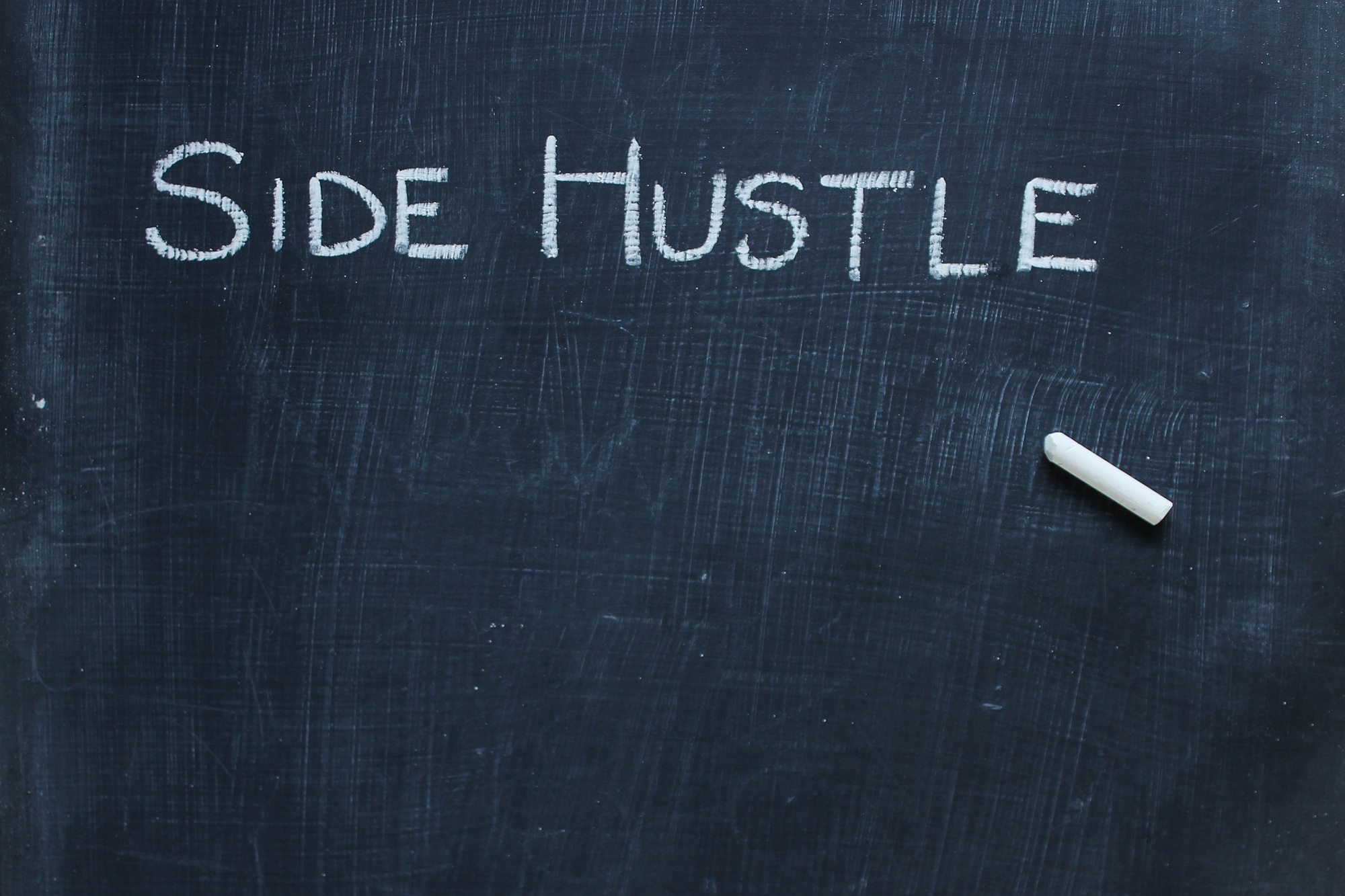 Side hustle written on chalkboard