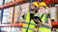 Warehouse worker standing check stock quantity of product and key information to tablet pc